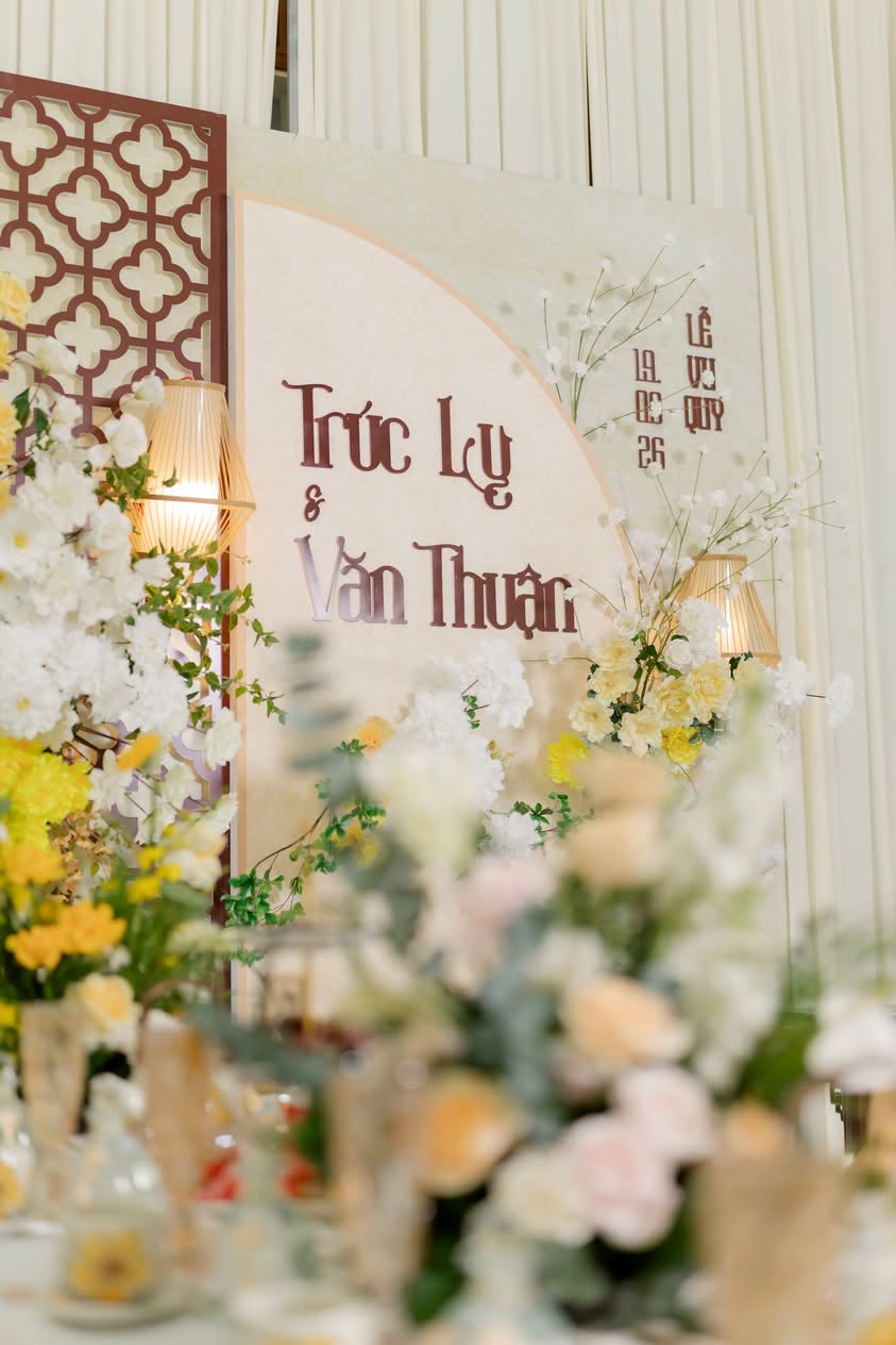 Bảng tên cô dâu chú rể giữa hoa vàng và trắng