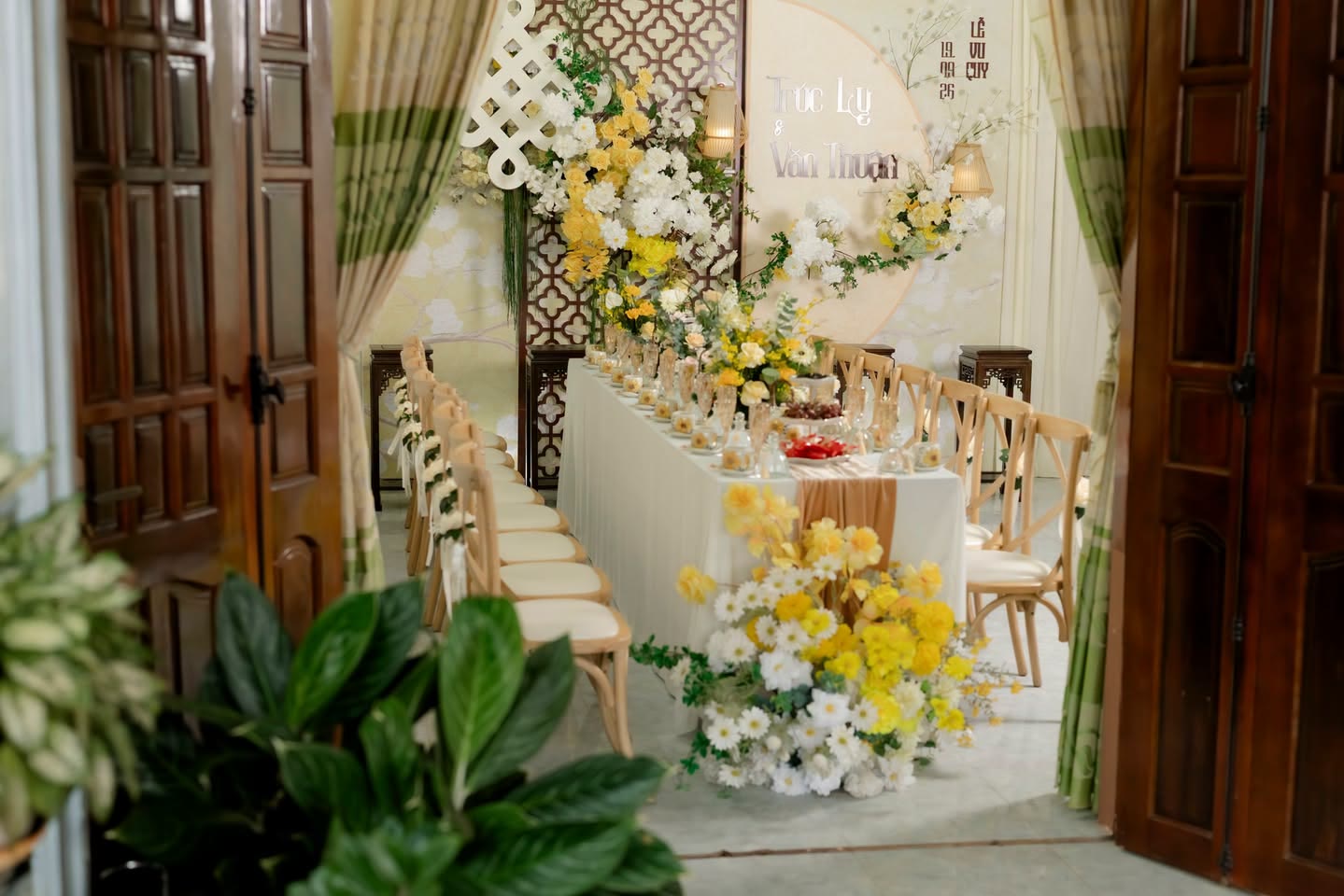 Bàn lễ trang trí hoa vàng nhìn qua cửa gỗ